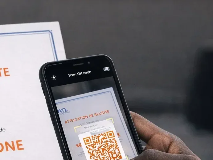 Un employeur scanne avec son téléphone le QR code d'une attestation de télépilote